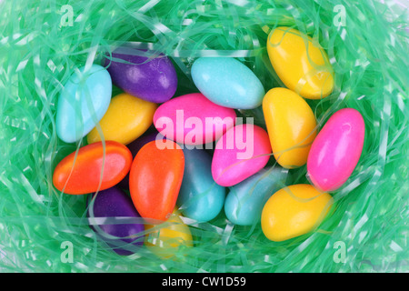 Multi colored candy Easter eggs in a nest of green grass decoration. Stock Photo