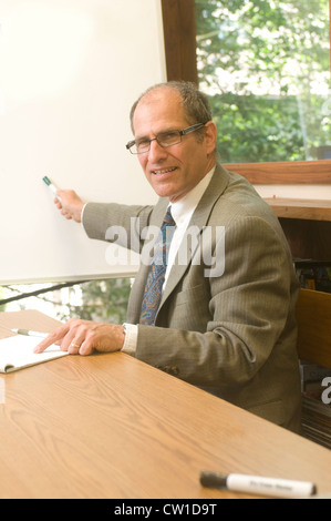 senior business executive in conference office giving presentation with blank white display board Stock Photo