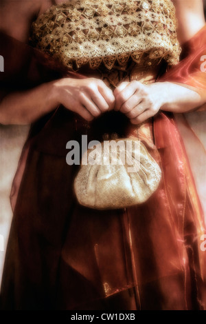 the hands of a woman in period dress holding an elegant handbag Stock Photo