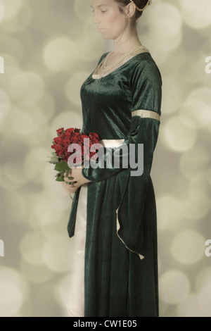 a woman in a Victorian dress with a bouquet of roses Stock Photo