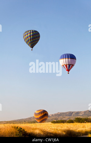Colourful hot air ballonns rising over the ridge. A generic portrait was taken early morning in Cappadocia, Turkey. Stock Photo