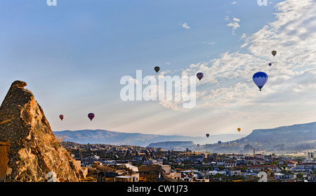 Early morning scene over the Goreme Valley in Cappadocia, Turkey. Drifting hot air balloons cut through the sun rays Stock Photo