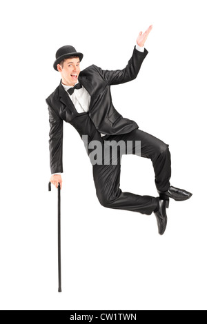 Magician jumping and holding a cane, isolated on white background Stock Photo