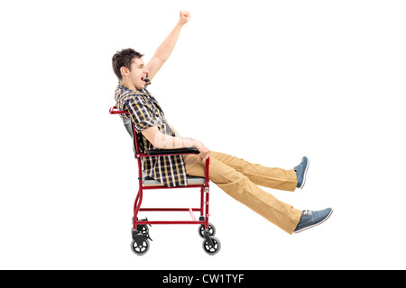 Happy young man sitting in a wheelchair and gesturing isolated on white background Stock Photo