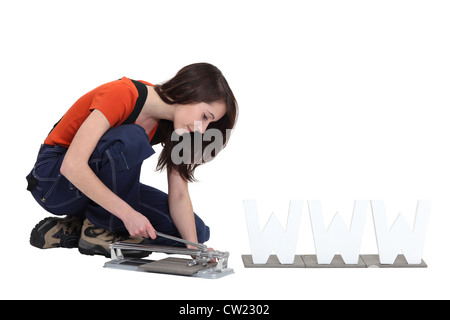 Woman using a manual tile cutter Stock Photo