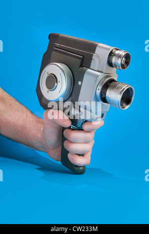 A man's hand holding an old fashioned 8mm film camera Stock Photo
