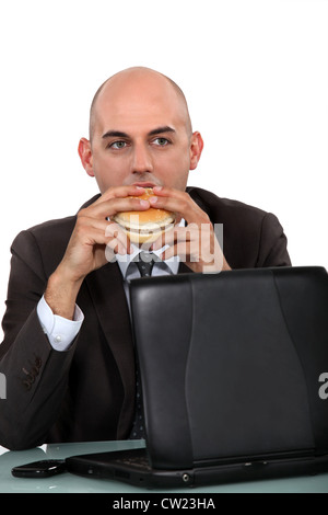 businessman eating a hamburger Stock Photo