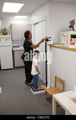 4 year old boy getting weighed by nurse at the doctors office Stock ...