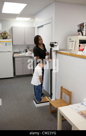5 year old boy getting weighed by nurse at the doctors office Stock ...