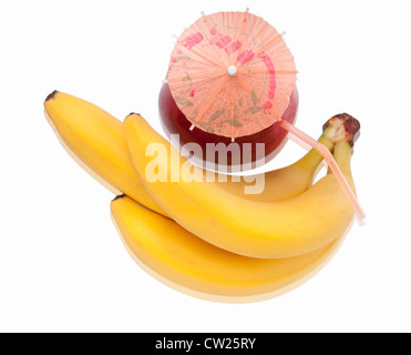 Bunch of fresh bananas and red apple with cocktail umbrella isolated on white background. Shallow depth of field. Stock Photo