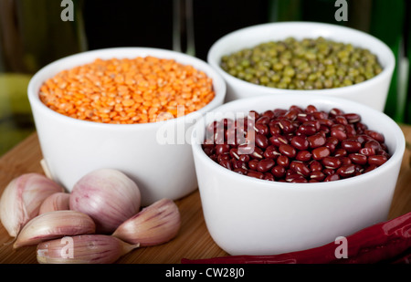 Three types of beans: lentils, mung and adzuki, with cloves of garlic. Stock Photo