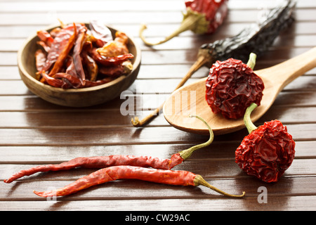 Assortment of dried chili peppers on wooden mat Stock Photo