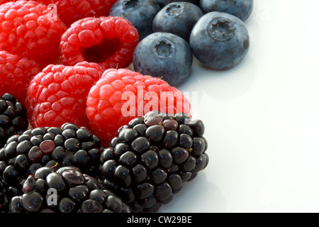 Raspberries, Blueberries and Blackberries on White Ceramic plate Stock Photo
