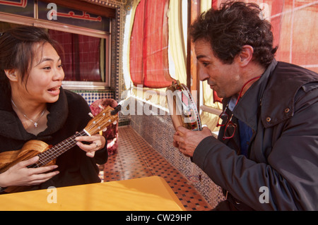 making music, Asian woman and her ukelele in Fes, Morocco Stock Photo