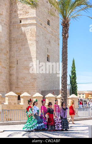 Calahorra Tower in Cordoba Spain. Women posing dressed in traditional Spanish flamenco dresses for the May Feria festival. Stock Photo