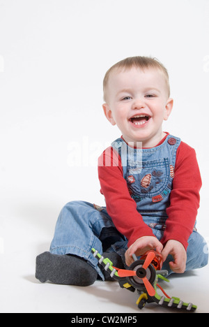 Little Boy Sitting and Laughing, Playing with Toy Airplane, Studio Portrait Cut Out on White Stock Photo