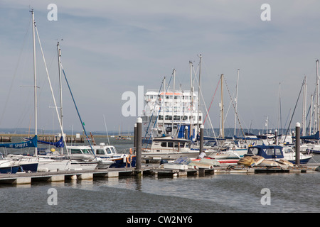 Wight Link ferry leaving Lymington for Yarmouth, seen through the masts of moored yachts Stock Photo