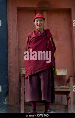 A Tibetan Buddhist monk dressed in traditional red robe with a red hat at Lamayuru Monastery in Ladakh, India Stock Photo