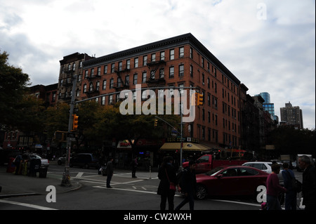 Grey sky view, to red tenement 'Gem Spa' news-stand, cars, people, autumn trees, 2nd Avenue St, Mark's Place crossing, New York Stock Photo