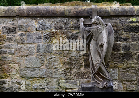 Statue of an angel holding on to a cross in the Dean Cemetery Edinburgh, Scotland. Stock Photo