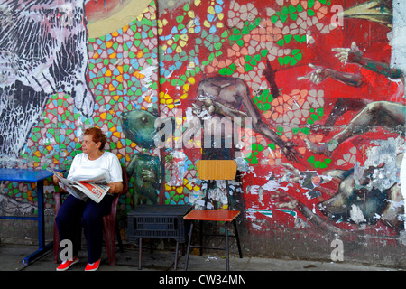 Buenos Aires Argentina,Avenida de Mayo,street scene,street,sidewalk,wall mural,peeling paint,dilapidated,chair,table,Hispanic woman female women,senio Stock Photo