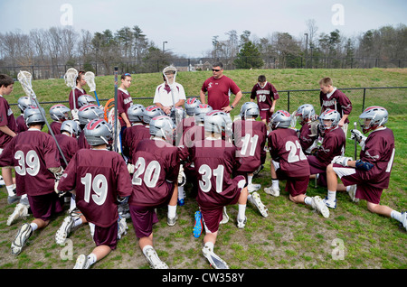 Coach discusses strategy with his high school lacrosse team Stock Photo