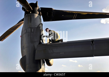 A US Air Force flight engineer inspects one of the tilt-rotors on a CV-22 Osprey July 5, 2012 at Cannon Air Force Base, NM. Stock Photo