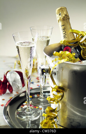 2 champagne glasses standing next to a radiator with a bottle of Moet Stock Photo