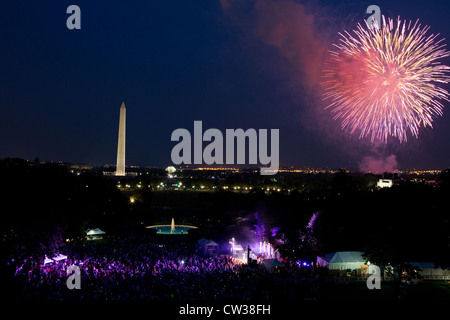 A crowd watches fireworks erupt over the National Mall from the South Lawn of the White House July 4, 2012 in Washington, DC. Stock Photo