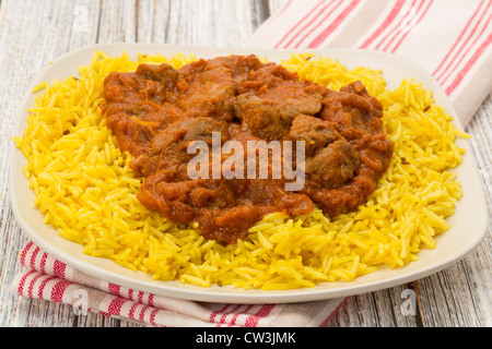 Indian meal of lamb rogan josh served with fragrant pilau rice - Studio shot Stock Photo