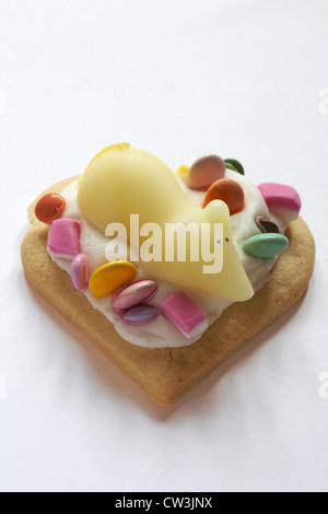 sugar mouse on heart shaped biscuit with dolly mixtures isolated on white background Stock Photo