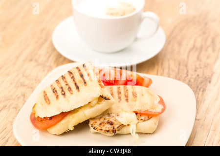 Toasted Chicken, tomato and mozzarella Panini sandwich that has been cut in half and placed on a plate Stock Photo