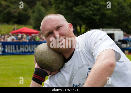 John Neill competing in Highland Games and throwing the stone. A traditional test of strength Stock Photo