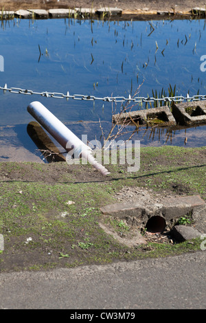 roadside surface water drainage pipe outletting to pond Stock Photo