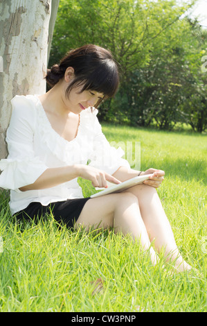 girl using tablet pc on the grass Stock Photo