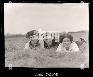 Vintage old photograph of a group of friends from the 1900 to 1910 period laid in a field on a summers day Stock Photo