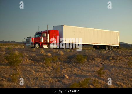 18-wheeler semi-trucks hit the highway driving down Interstate Highway 15 between Los Angeles and Las Vegas Nevada. Stock Photo