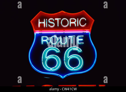 This is a road sign that says Historic Route 66. It is a neon sign in red, white and blue against a black night sky. Stock Photo