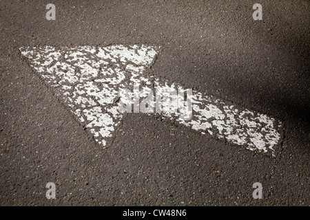 White arrow sign painted on road surface Stock Photo