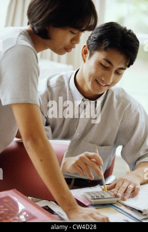 Young couple calculating bills using a calculator Stock Photo