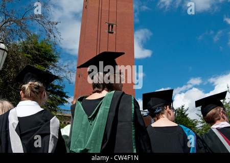 Back view of motar board hats and gowns of medical student graduates at Birmingham University UK with old joe clock tower Stock Photo