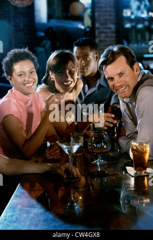 Portrait of two young couples smiling at a bar counter Stock Photo
