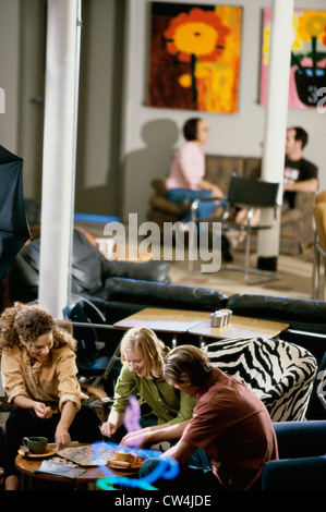 High angle view of two young women and a young man playing a board game Stock Photo