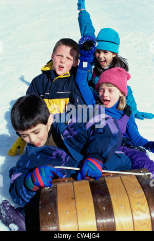 High angle view of two boys and two girls riding on a sled Stock Photo