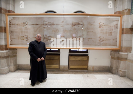 Father Christopher in front of the Shroud of Turin (a replica) in the Notre Dame de France Hospice Museum, Jerusalem, Israel Stock Photo