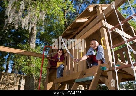 Friends Playing With Sword And Stick In Jungle Gym At Forest Stock