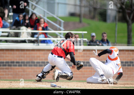 Baseball high school catcher applying a tag to a sliding runner to record an out at the plate. USA. Stock Photo