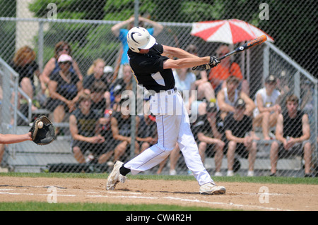 Pitch settle into the catcher's glove as a hitter swings and misses, striking out during a high school playoff game. Stock Photo