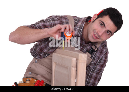 Tradesman using a measuring tape Stock Photo