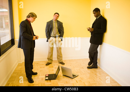Businessmen using mobile phones in an office Stock Photo